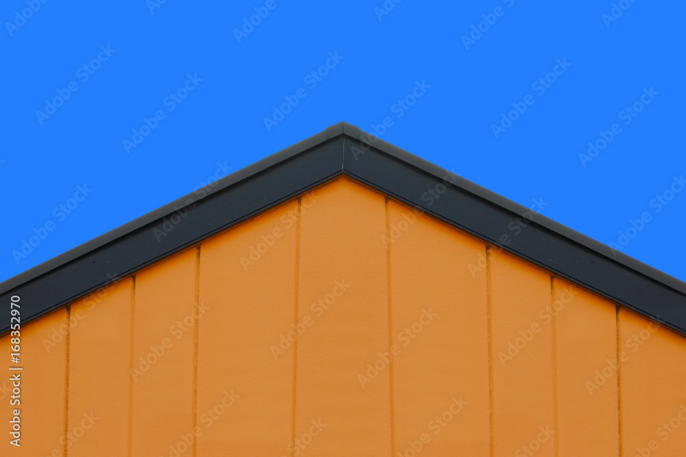 orange concrete wall gable roof house with blue sky