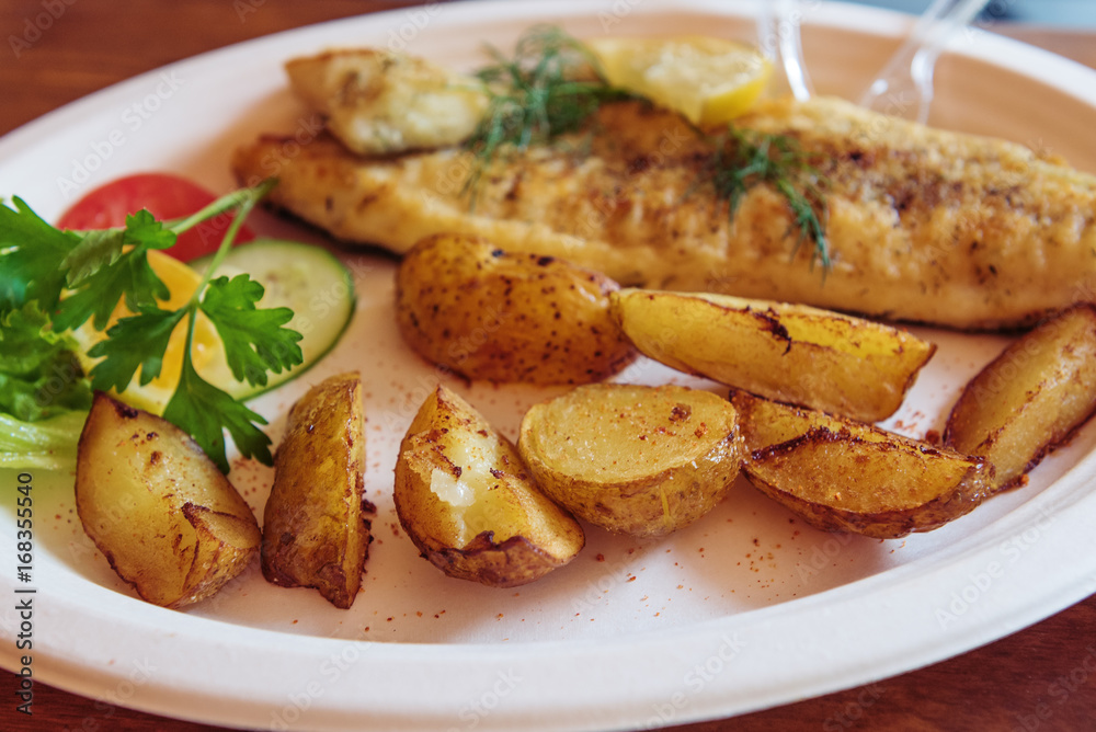 Fish dish - traditional Baltic fried cod fish served with baked potatoes and vegetables. Fish dish - traditional Baltic fried cod fish served with baked potatoes and vegetables.