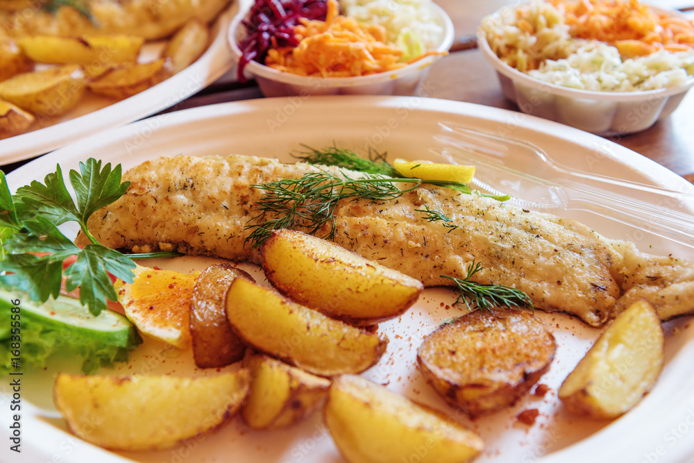 Fish dish - traditional Baltic fried cod fish served with baked potatoes and vegetables.