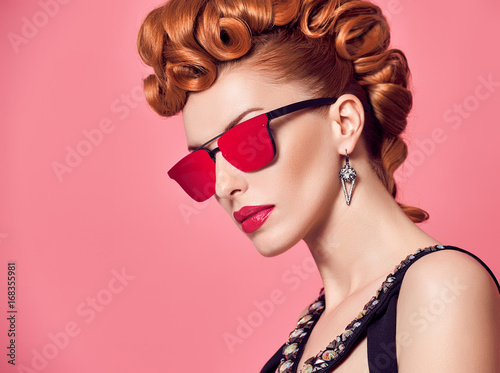 Fashion Portrait Redhead Model Sexy Girl. Stylish Mohawk hairstyle, Fashion Makeup. Glamour Sunglasses, Party Disco Outfit. Beauty Woman in Trendy Luxury Accessories. Playful cheeky fashion girl.