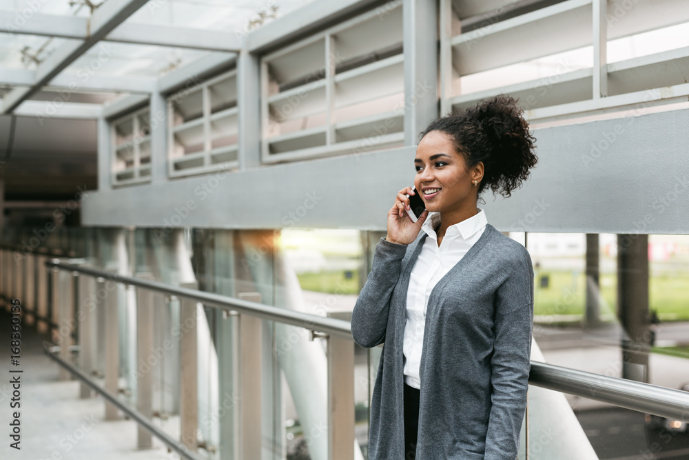 Businesswoman standing in terminal and making phone call Businesswoman standing in terminal and making phone call