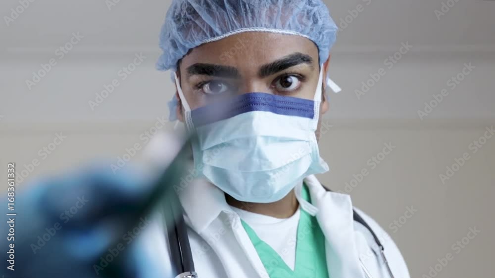 Surgeon bringing scalpel closer to screen Surgeon bringing scalpel closer to screen