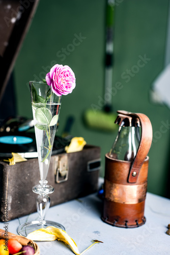 Fototapeta Naklejka Na Ścianę i Meble -  Pink rose in a glass on a background of a gramophone