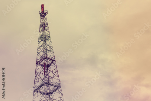 Cellular tower on a cloudy sky background, toned