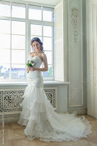 Young attractive bride on wedding gown in studio