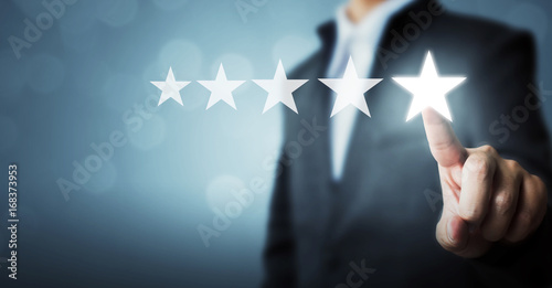 Businessman pointing five star symbol to increase rating of company photo