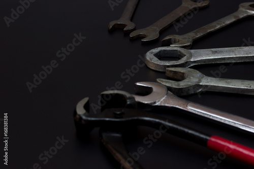 Wire cutters, pliers and wrench. Low key Tools on darkness background.