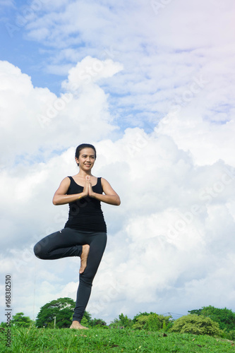 Fototapeta Naklejka Na Ścianę i Meble -  Woman practicing  yoga relax in nature and blue sky background