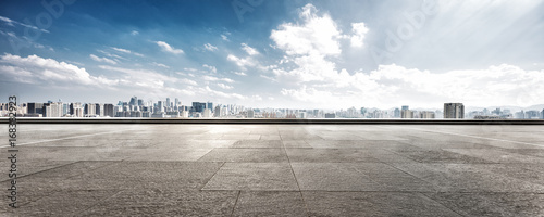 empty floor and cityscape of modern city against cloud sky photo
