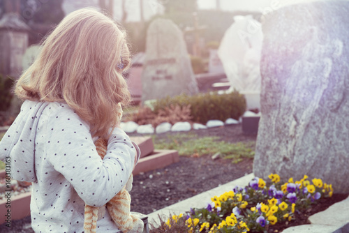 sad girl in front of grave photo