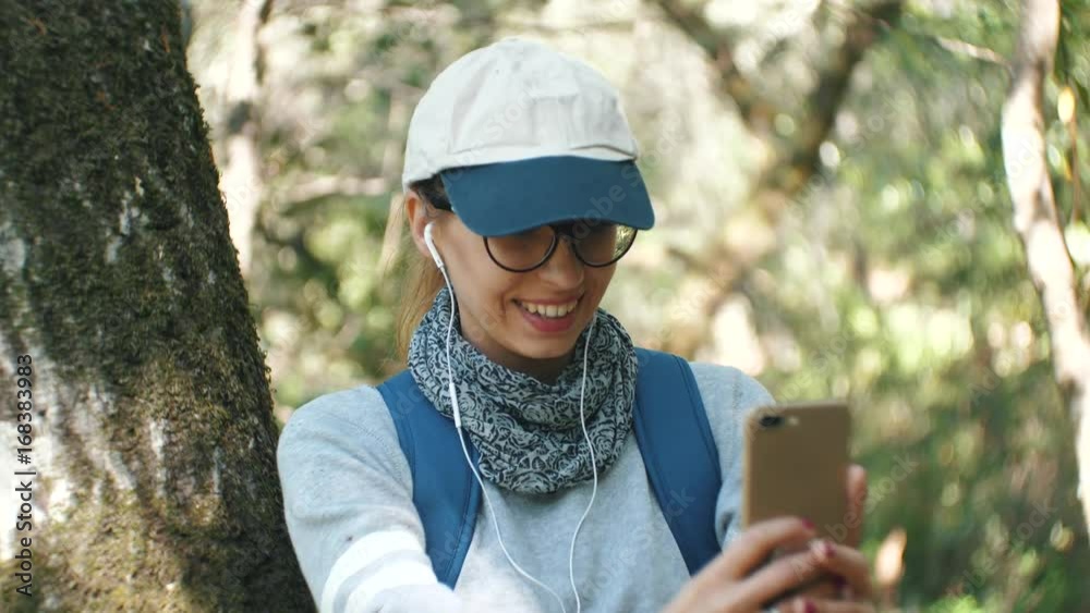 Young girls is shooting selfie while hiking in the woods Young girls is shooting selfie while hiking in the woods