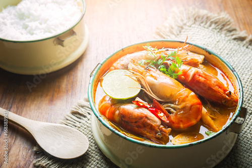 Thai food, River prawn spicy soup or tom yum goong on wooden table photo