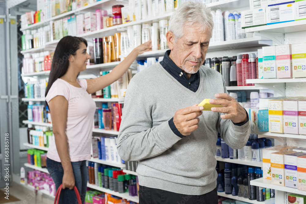 Male And Female Customers Shopping In Pharmacy