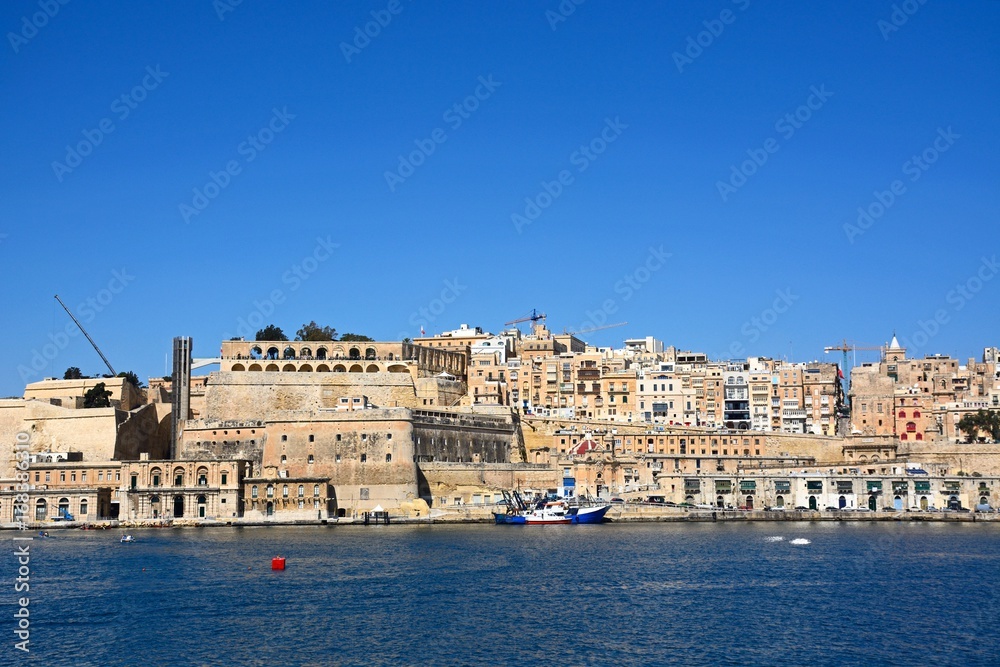 Valletta waterfront buildings including Upper Barrakka Gardens seen from across the Grand Harbour in Vittoriosa, Valletta, Malta.