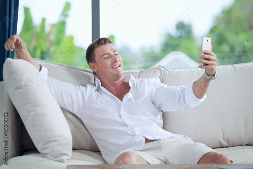 portrait of young man making self photo with his mobile phone