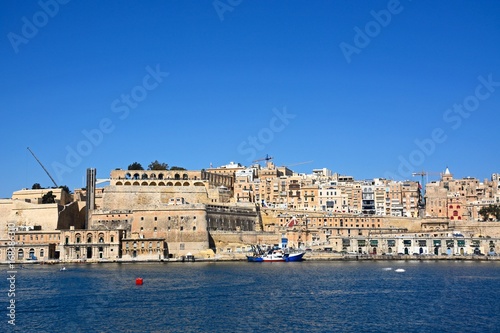 Fototapeta Naklejka Na Ścianę i Meble -  Valletta waterfront buildings including Upper Barrakka Gardens seen from across the Grand Harbour in Vittoriosa, Valletta, Malta.