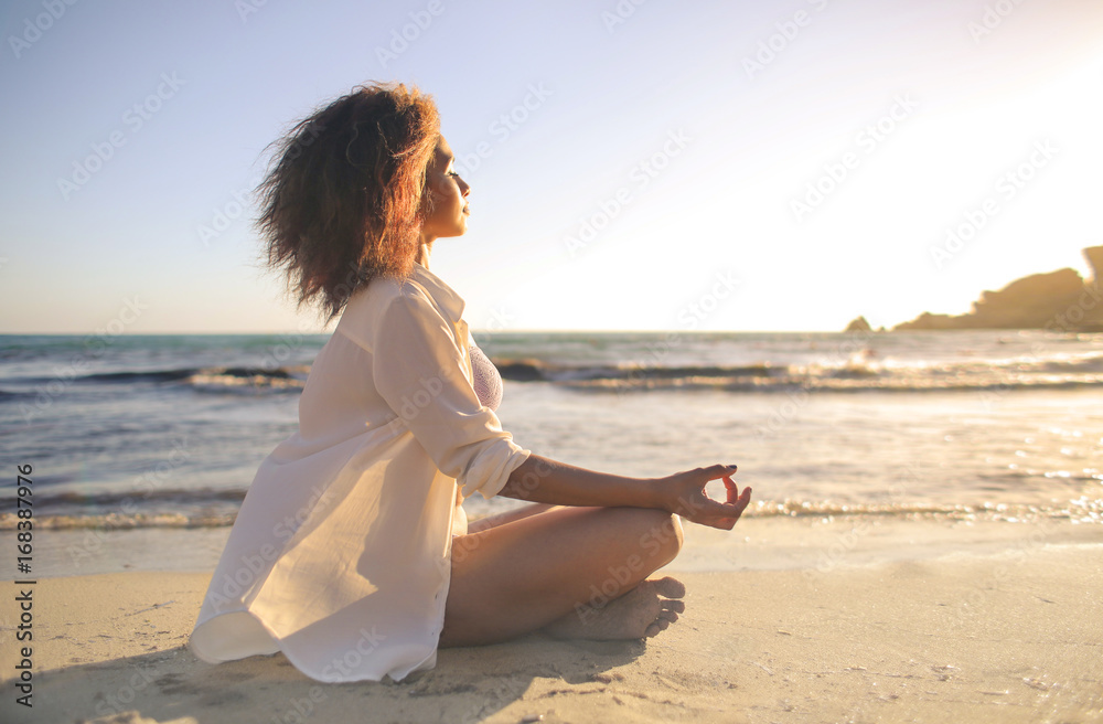 Girl doing yoga at the beach, at sunset time - obrazy, fototapety, plakaty 