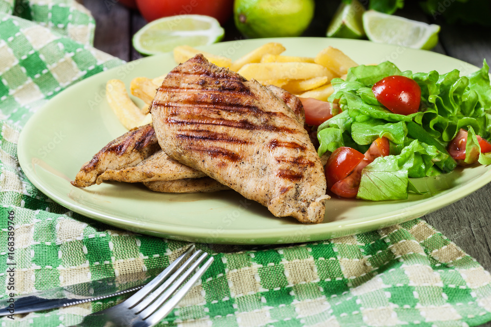 Grilled chicken breasts served with fries Grilled chicken breasts served with fries