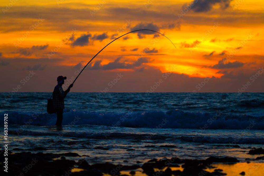 Fisherman silhouette on sunset tropical beach, Phuket, Thailand.
