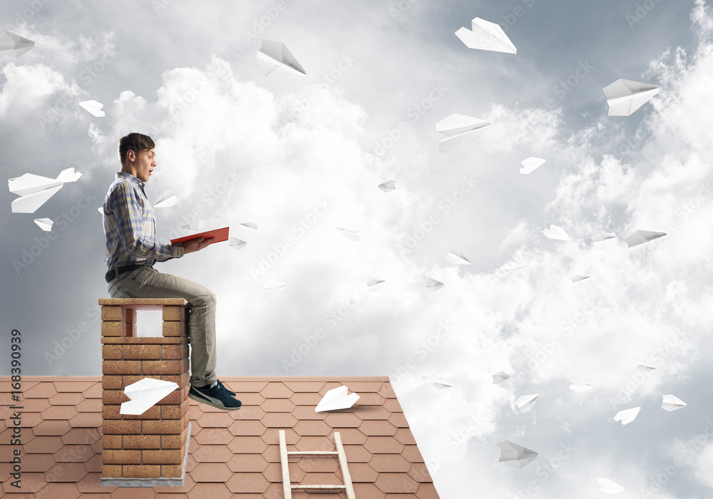 Handsome student guy reading book and paper planes flying in air Handsome student guy reading book and paper planes flying in air