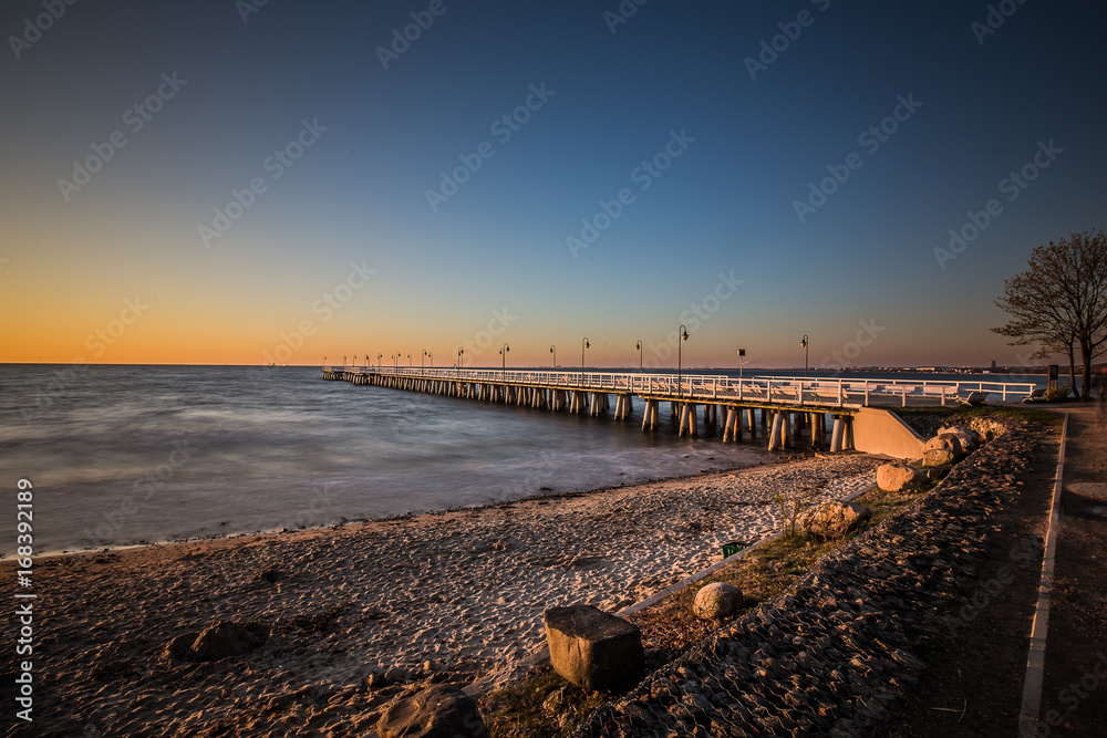 Obraz premium Amazing sunrise on the pier at the seaside. Gdynia Orlowo, Poland