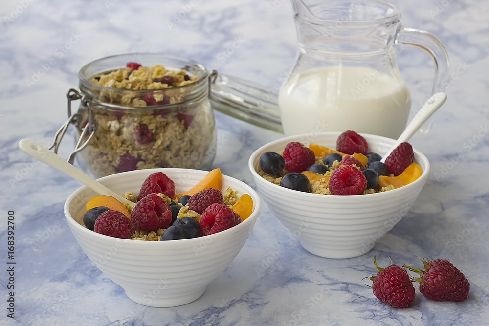 Bowls of granola with fresh fruit on marble table. Bowls of granola with fresh fruit on marble table.