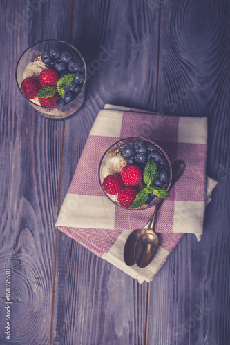 yogurt with muesli and berries on a wooden table