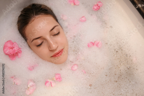 Woman relaxing in bath with...