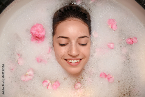 Woman relaxing in bath with...