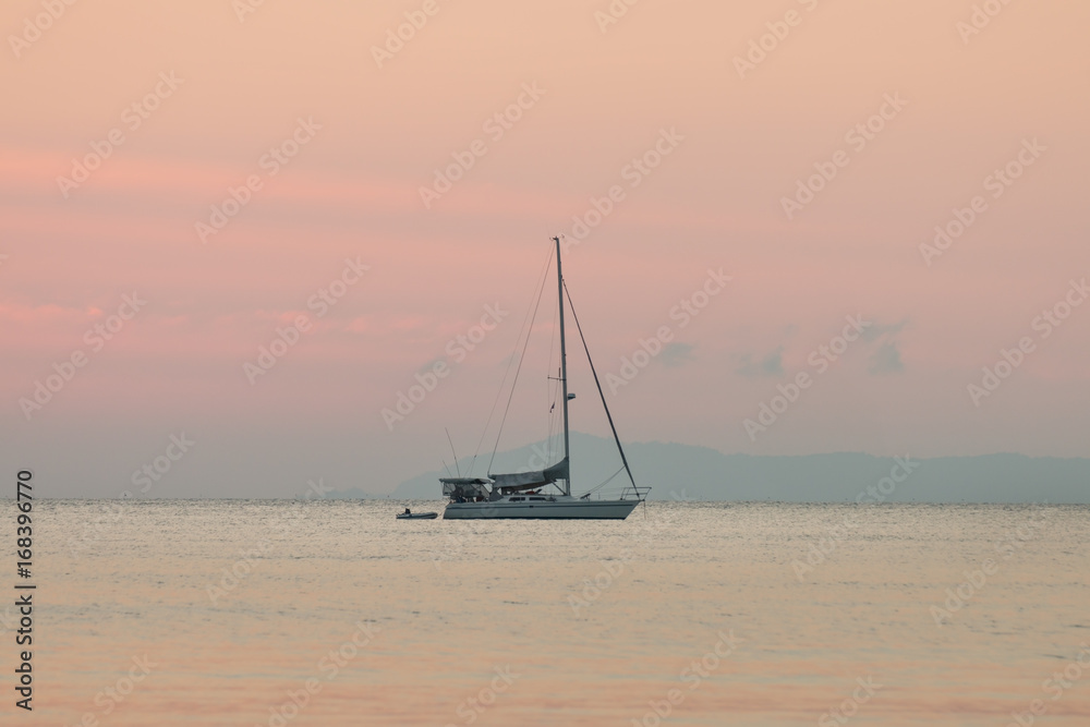 sailboat in the sea of summer background and sunset in the evening time.