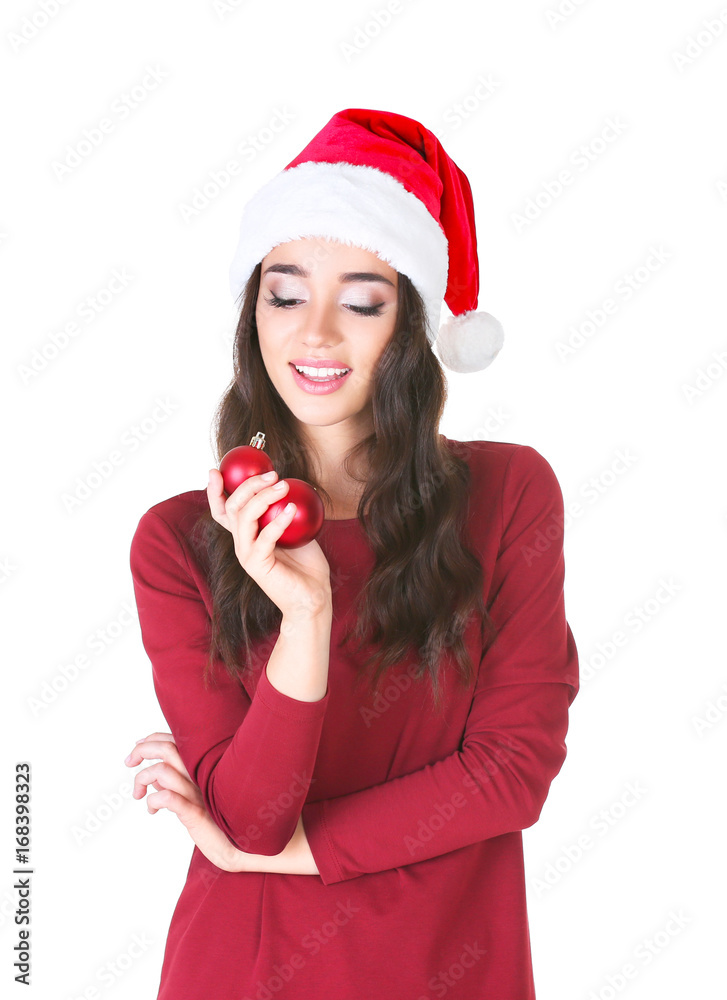 Pretty lady in Christmas hat holding shiny baubles on white background