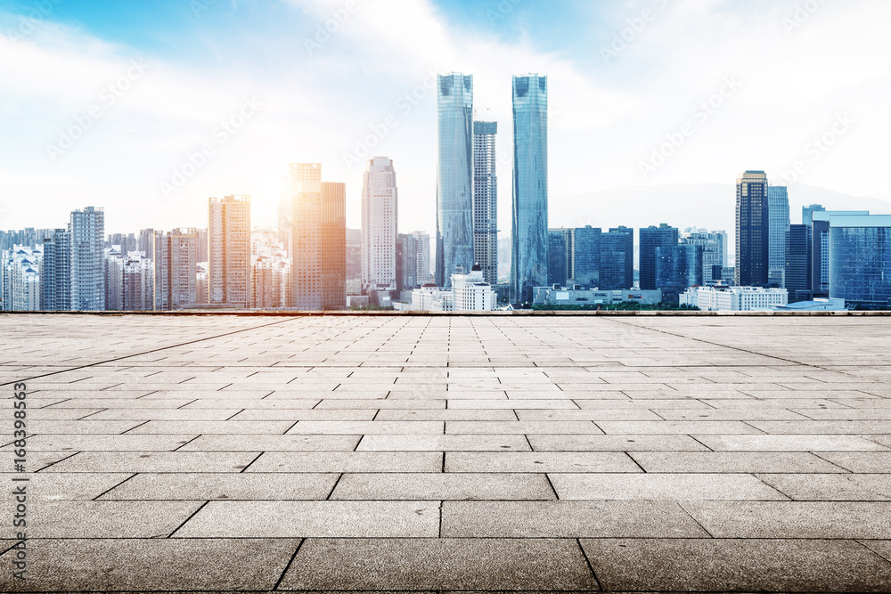 empty concrete road and cityscape in blue sky at dawn