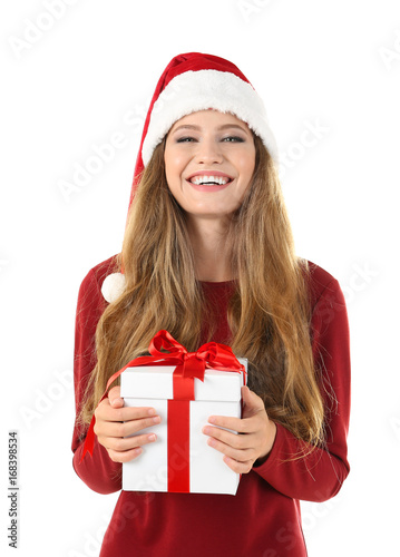 Pretty young lady in Christmas hat holding gift box on white background