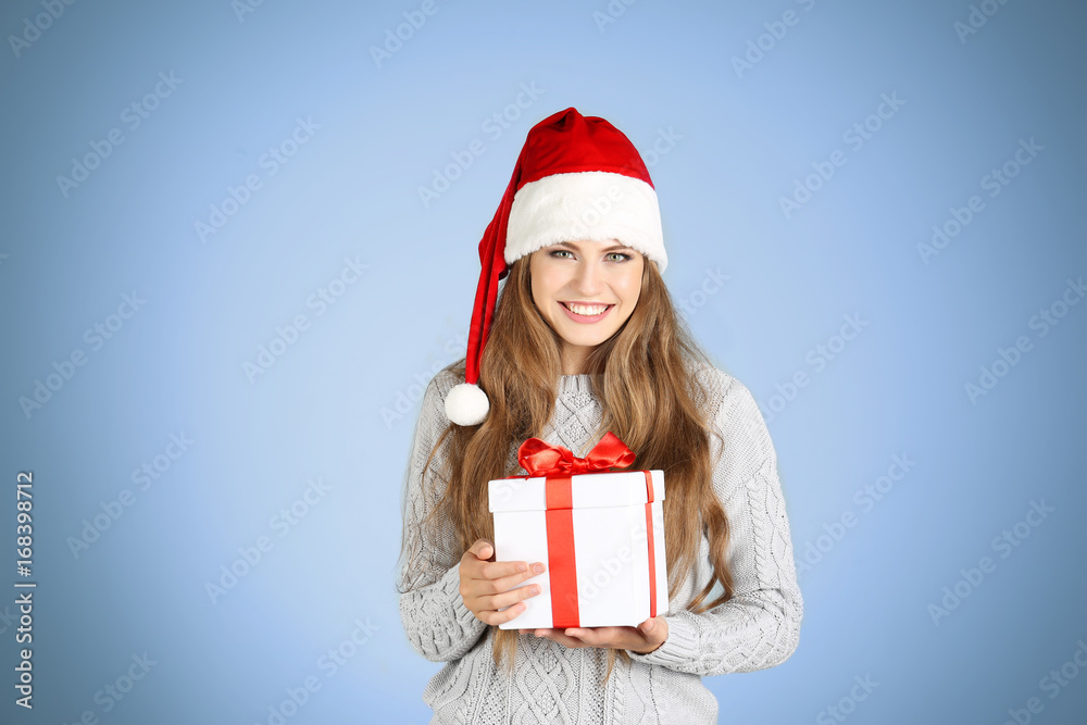 Pretty young lady holding gift box on color background Pretty young lady holding gift box on color background