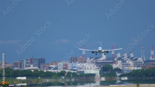 Airplane landing on runway with shimmering heat haze

