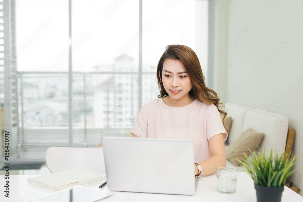 Happy businesswoman using laptop at workplace in office