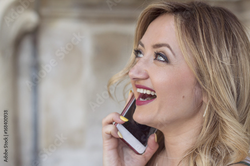 Fashion portrait of young beautiful woman talking on cell phone.