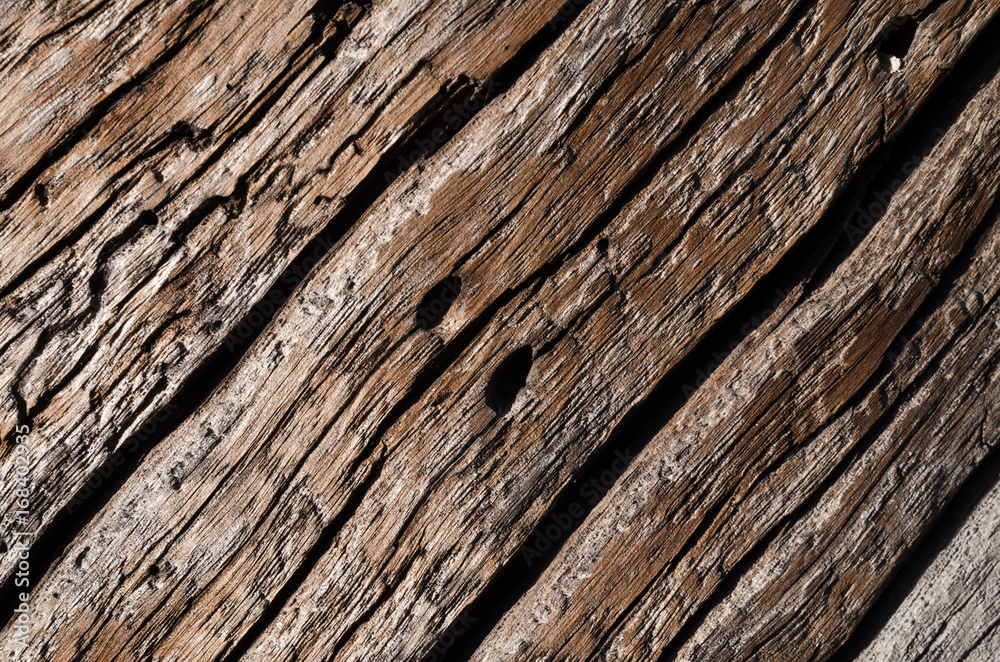 The texture is an old gray, rotted wooden board with deep wavy cracks and holes. The texture is an old gray, rotted wooden board with deep wavy cracks and holes.