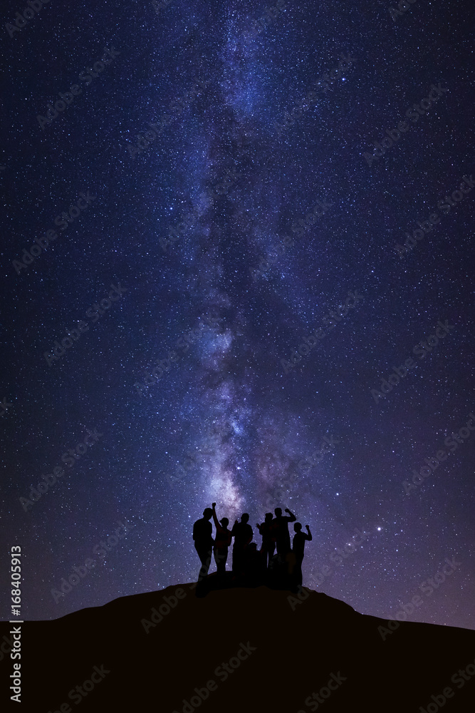 Obraz premium Landscape with milky way, Night sky with stars and silhouette of happy people standing on high moutain
