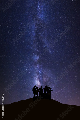 Landscape with milky way  Night sky with stars and silhouette of happy people standing on high moutain