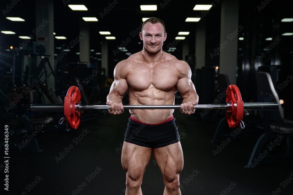 Brutal strong bodybuilder man pumping up muscles and train gym Brutal strong bodybuilder man pumping up muscles and train gym