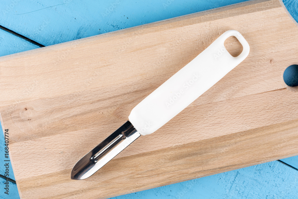 Flat lay above peeling knife for fruits and vegetables on the wooden board Flat lay above peeling knife for fruits and vegetables on the wooden board