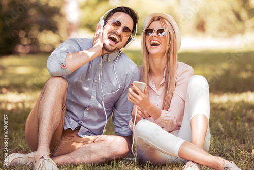 Konstfotografi Loving young couple in summer park listening music.