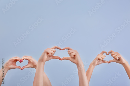 Billede på lærred Hearts made by raised hands on light background