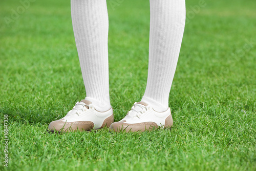 Legs of young golf player on course in summer day