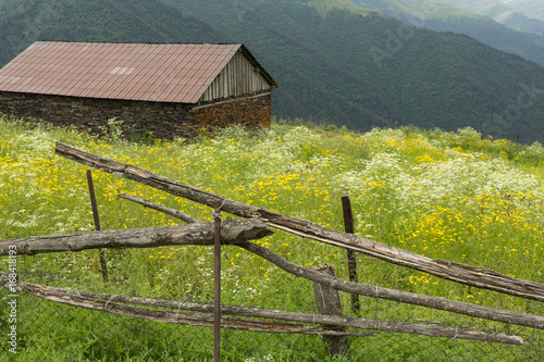 view of an abandoned cabin and the mountains of the Tusheti village of Bochorna