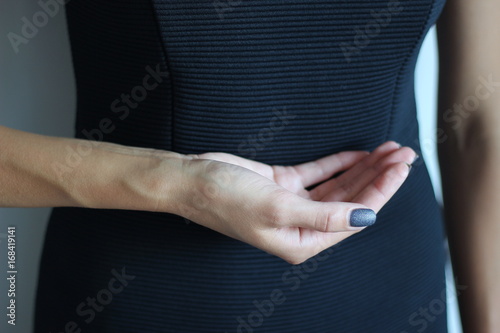 Young woman's hand keeps something. Gesture