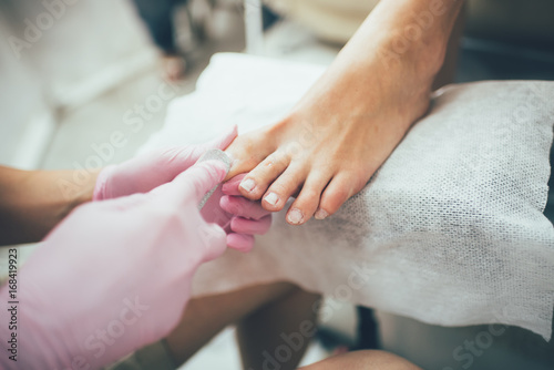 hands making a pedicure. Beauty salon, female feet, real picture