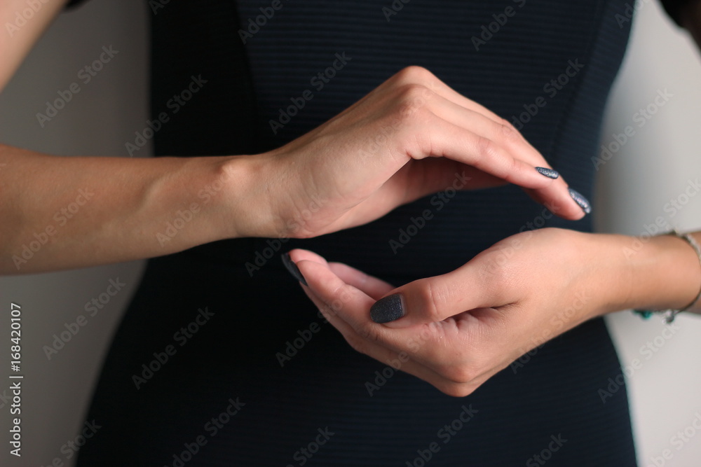 Female hands show a circle or a ball. gesture