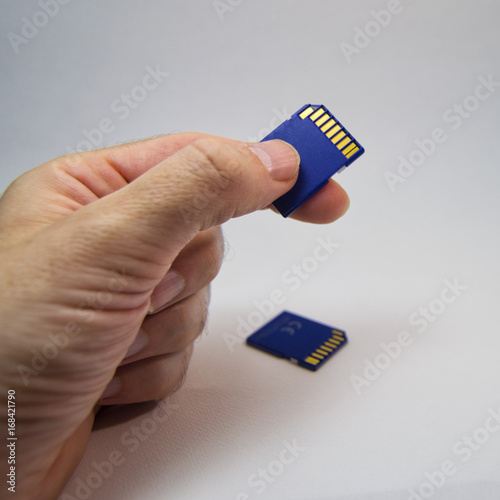 man hand holding a memory card on a white background.